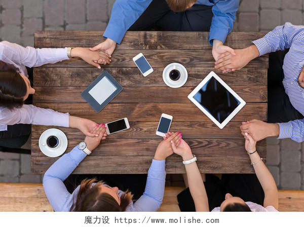木质桌面上一组牵手交谈平板电脑咖啡电话
